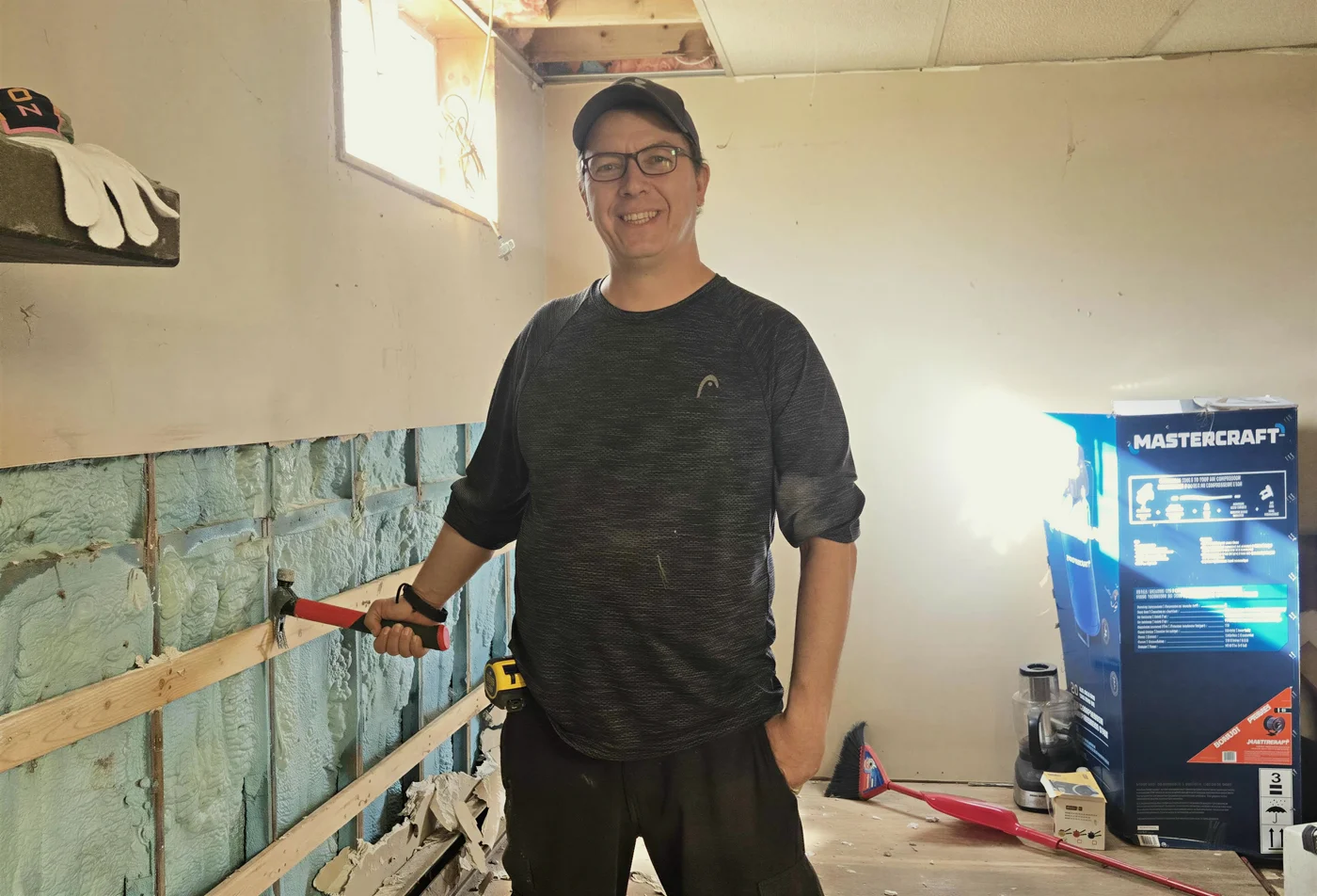 Charles Deschênes sur un de ses chantiers, marteau à la main